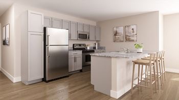 A kitchen with a island and stainless steel refrigerator